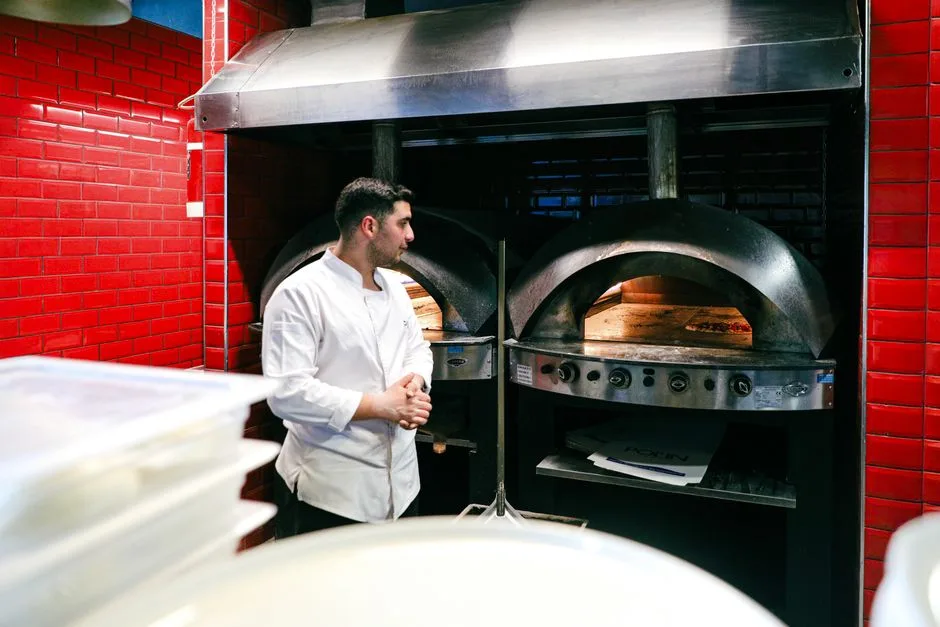 Busy commercial kitchen in Hammonton restaurant — grease-laden air rising above the cooking line into exhaust hood